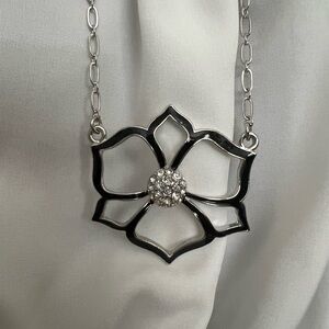 Exquisite flower necklace with black enamel attached to a silver chain.